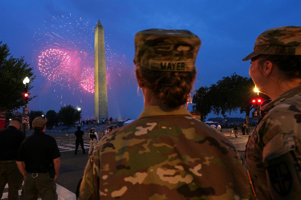 U.S. Army 2nd Lt. Hayle Mayer, left, and Corporal Addison Merrell, watch fireworks at the Washington Monument while attending a military parade commemorating the Army's 250th anniversary 