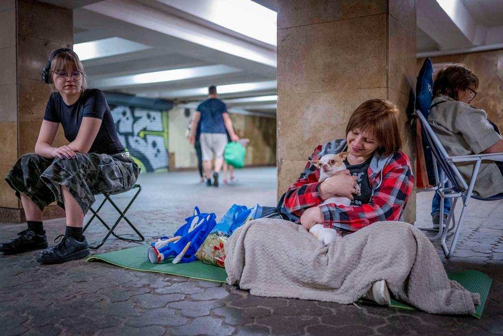 People hide in a metro station, being used as a bomb shelter, during a Russian drones attack in Kyiv, Ukraine