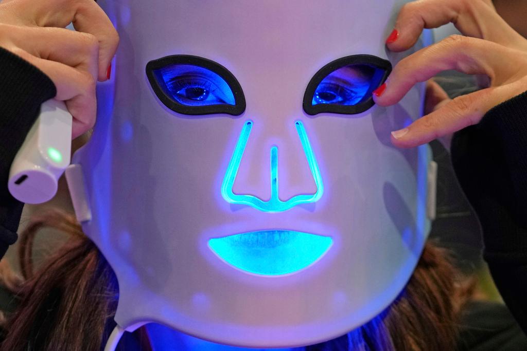 Representative for a light therapy mask company demonstrates one of the devices during the CES tech show