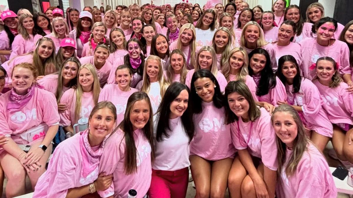 A hundred women in pink surrounding Tonya Prewett in hot pink pants