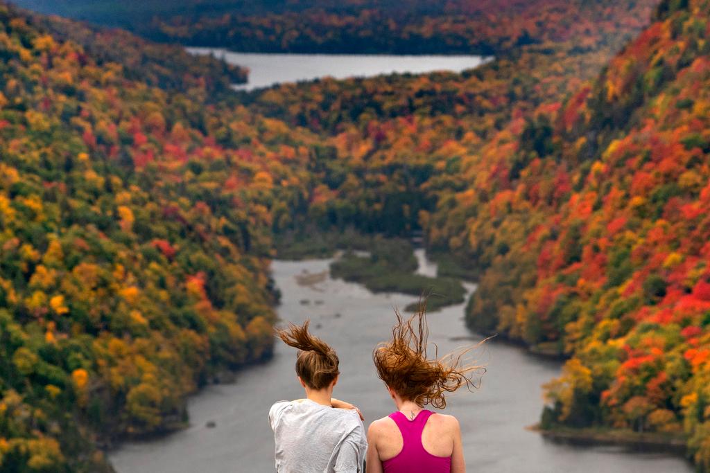 Wind whips the hair of two visitors taking in the view at the Indian Head vista overlooking Lower Ausable Lake in the Adirondacks